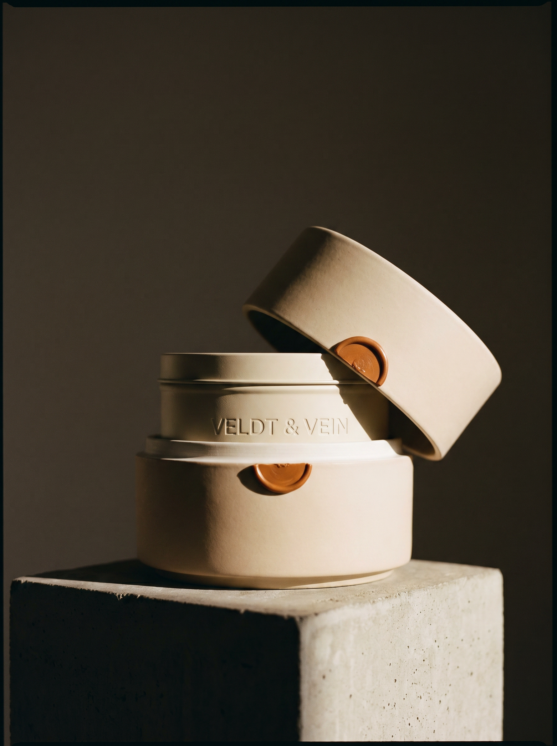 Three stacked Veldt Recovery Balm porcelain tins with terracotta wax seals.